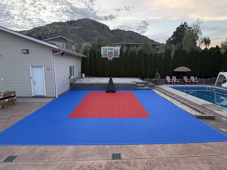Blue and red basketball court next to a swimming pool